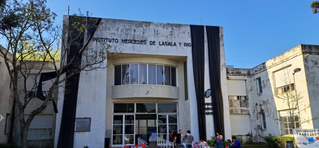 Edificio del Instituto Mercedes de Lasala y Righi con fachada en mal estado y un grupo de personas frente a la entrada.